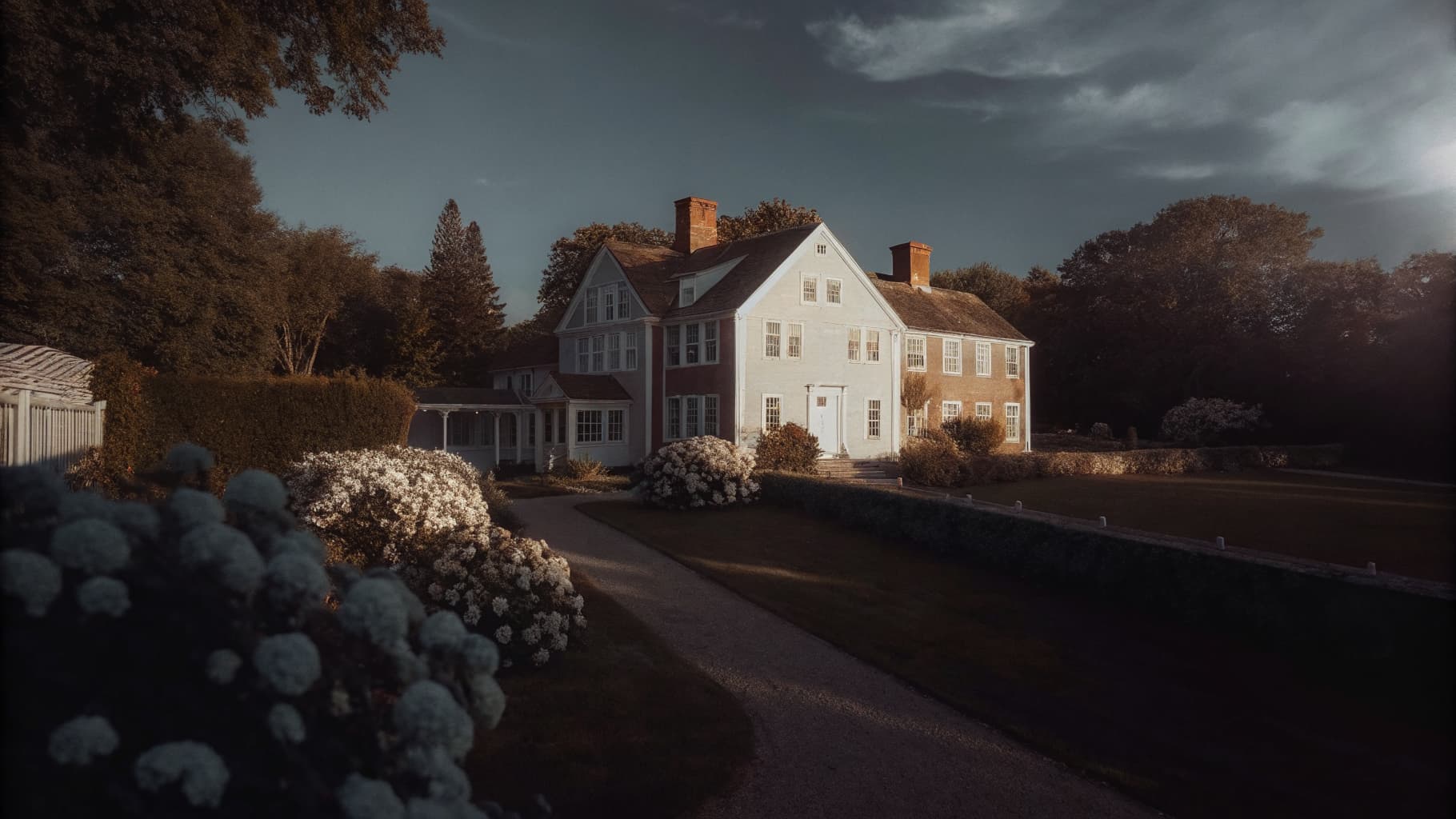 Aerial view of a manicured Fairfield County estate garden with hydrangea plantings, stone pathways, and colonial architecture at golden hour